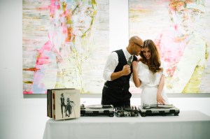 Newlyweds at their wedding in front of large paintings