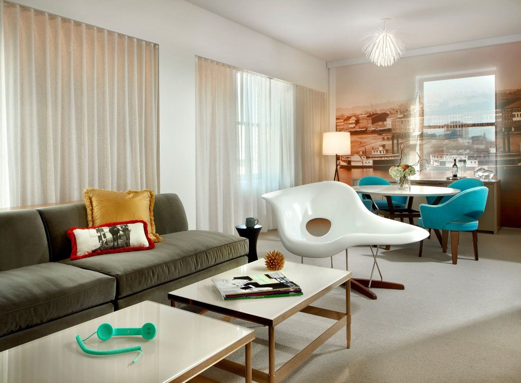 A stylish living area with a couch, chairs and coffee table in a hotel suite