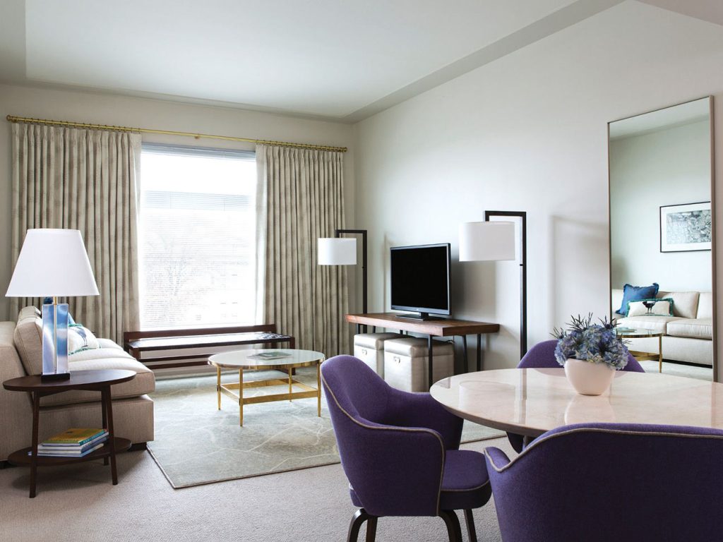 Couch, tv, round table with chairs in Luxury Suite at 21c Bentonville